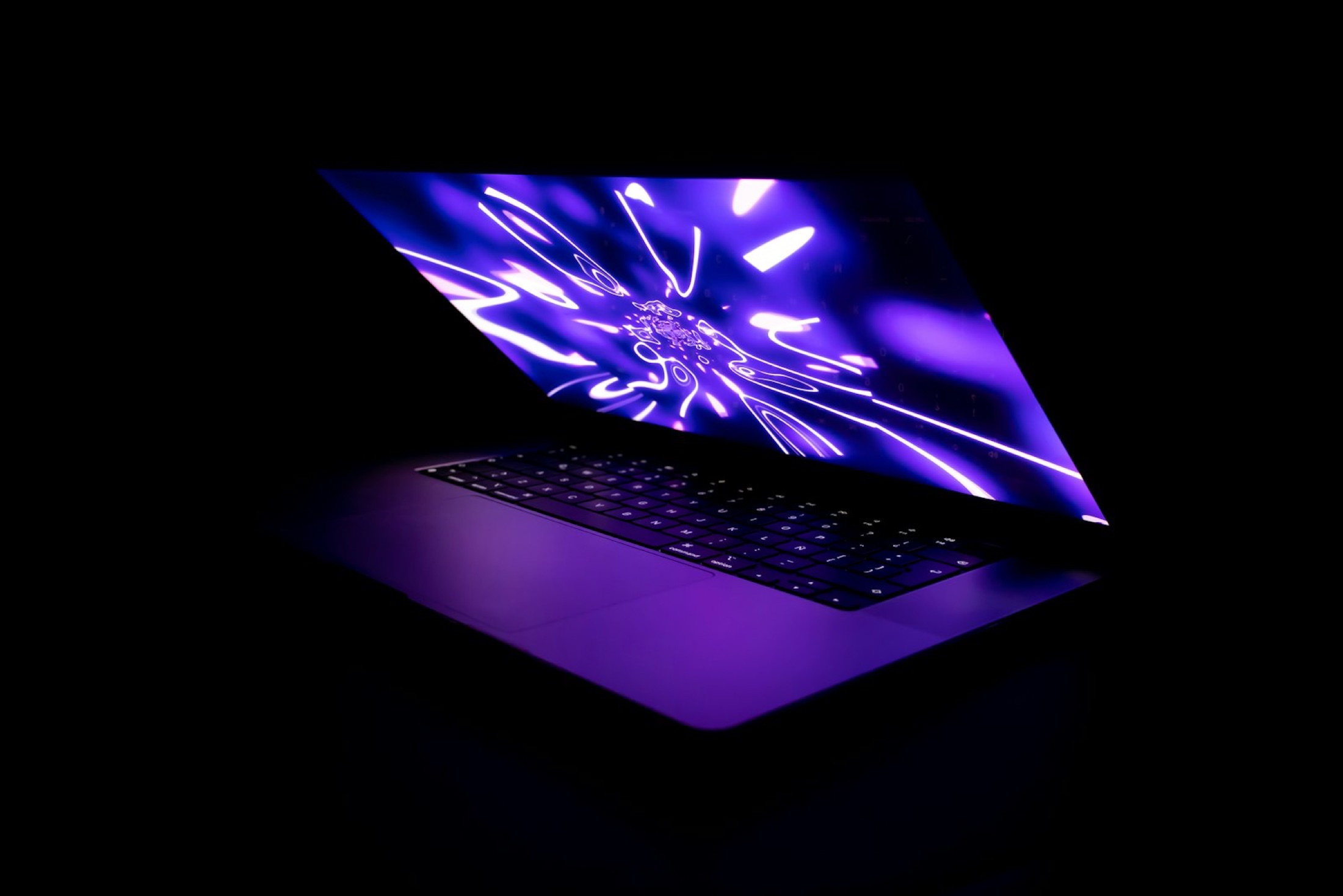 Laptop mit leuchtendem Bildschirm im Dunkeln